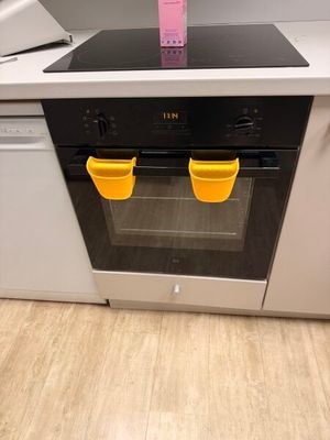 two yellow cups on top of a stove in a kitchen