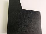 a close up of a piece of black paper on a white surface