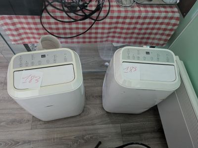 two small air conditioners sitting next to each other on the floor