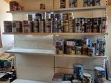 many cans of paint on the shelves in the room