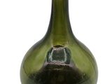 a green glass bottle with a small hole in it