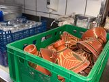 a green crate filled with plates and bowls in a kitchen