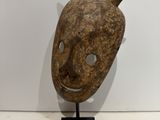 an image of a wooden mask with horns on a black stand