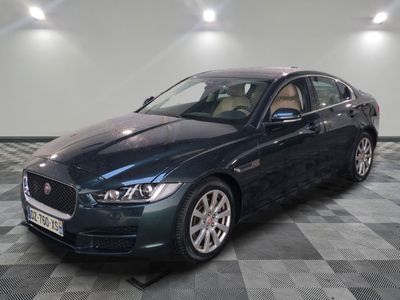 La Jaguar est garée sur un sol en damier dans un garage.