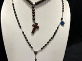 a close up of a necklace on a mannequin with a cross on it