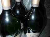 three bottles of champagne sitting on top of a refrigerator