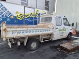 un homme debout devant un camion sur lequel est accrochée une pancarte