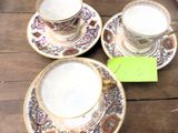 trois tasses et soucoupes posées sur une table en bois