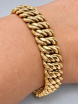 une photo d'un bracelet en or au poignet d'une femme