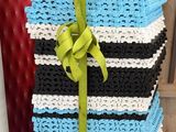 a blue and black striped bag with a green ribbon