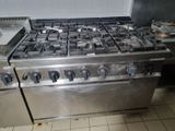 a silver stove with four burners and a pot on top of it