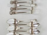 several silver spoons and forks are lined up on a white surface