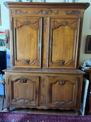 une photo d'une armoire en bois dans une pièce où se trouve un tapis au sol