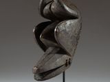 a close up of a sculpture of a face on a stand