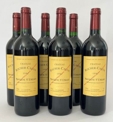 six bouteilles de vin sont alignées sur une surface blanche