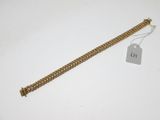Gros plan sur un bracelet en or portant une étiquette