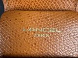 the inside of a brown leather bag with a gold logo on it