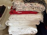 a lot of folded blankets on a bed