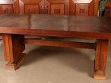 a large wooden table with a bench in the middle of it