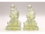 paire de figurines en verre représentant un homme et une femme tenant un bébé dans leurs bras