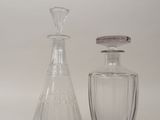 deux bouteilles en verre posées l'une à côté de l'autre sur une surface blanche