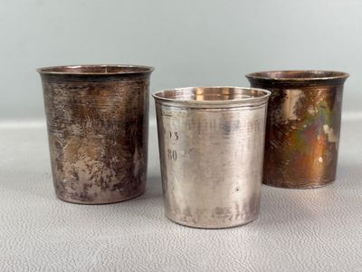 three silver cups sitting next to each other on a table