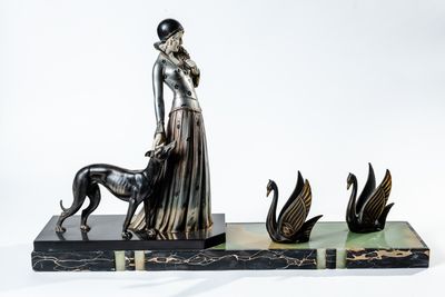 statue of a woman with a dog and swans on a marble base