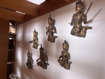 il y a beaucoup de statues accrochées au mur de la pièce