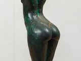 statue of a woman sitting on a pedestal with a hat on top of her head