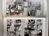 two pages of comics on a table with a cup of coffee