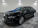 une Audi noire garée dans un garage au sol carrelé