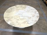a marble table with a white top on the floor