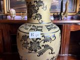 a large vase sitting on a table in front of a painting