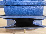 a blue purse sitting on top of a wooden table