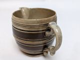 a close up of a coffee cup with a handle on a white surface
