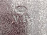 an image of a close up of a leather bag with a logo on it