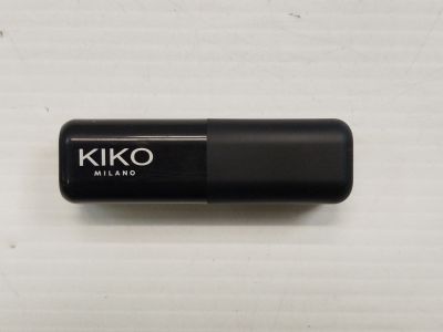a close up of a black pill on a white surface