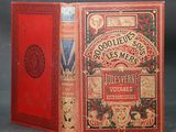 un vieux livre à la couverture rouge posé sur une table