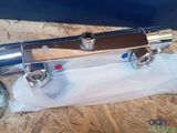 an image of a chrome plated water heater on a piece of plywood