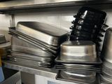 many pots and pans stacked on a shelf in the kitchen