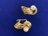 paire de boucles d'oreilles dorées ornées de perles sur un fond bleu