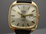 une montre-bracelet en or avec un bracelet en cuir noir