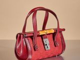 a red purse sitting on a table with a yellow handle