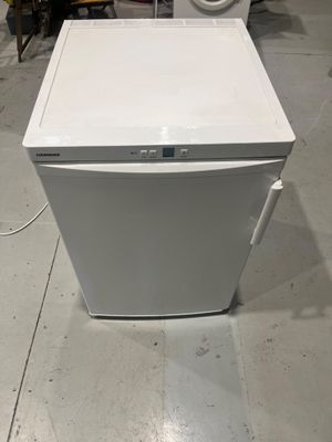 un lave-vaisselle blanc posé par terre à côté d'une machine à laver