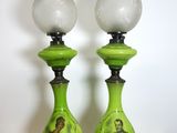 une paire de lampes en verre vert posées sur une table en bois, avec un mur blanc en arrière-plan