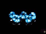 a pair of blue crystal earrings on a black background
