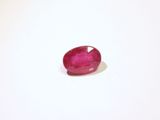 gros plan d'une pierre de rubis rouge sur une surface blanche