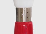 a red and white table lamp on a white surface