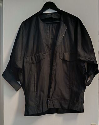 black leather jacket hanging on a white door with a black hanger