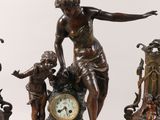 three bronze figurines of a woman and two children with a clock